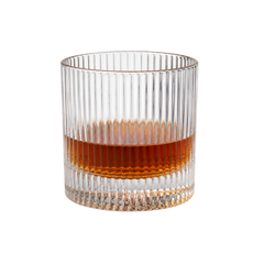 Premium ribbed heavy base whisky tumbler glass with whisky pour on a light background