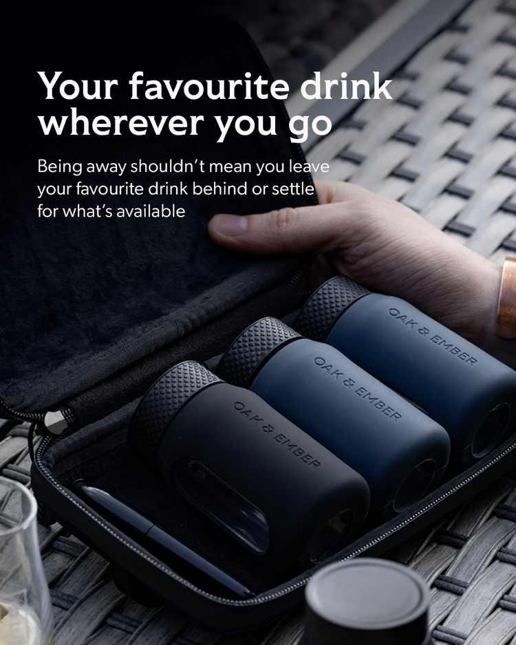 Three Oak & Ember portable drink mixers in a black zip case, shown open with a hand resting on the lid. Large promotional text reads 'Your favourite drink wherever you go' on a dark background.