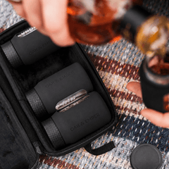 Pouring whisky from an Oak & Ember Flight Flask at a picnic